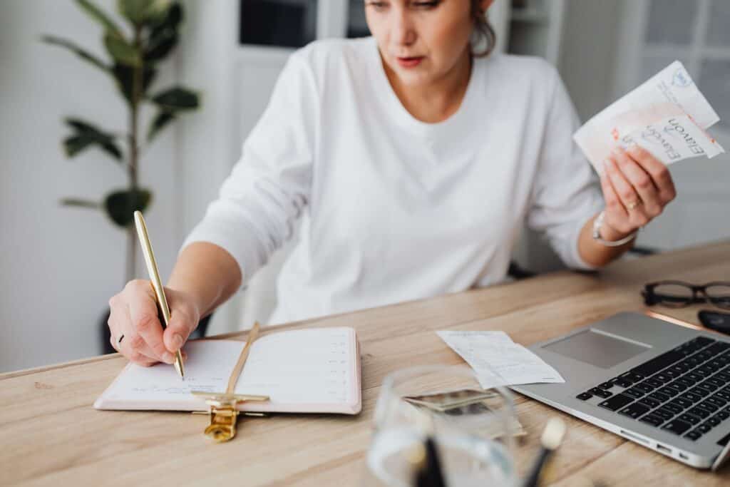 A business owner looking at a financial plan with a laptop and a pen