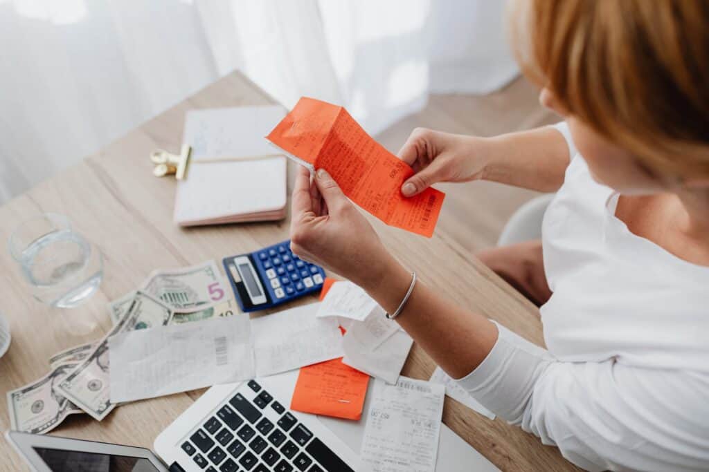 A business owner looking at a financial plan with a laptop and a calculator